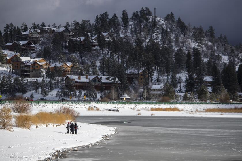 BIG BEAR LAKE, CA - DECEMBER 29: Residents and visitors enjoy the day along the shore of a partially frozen Big Bear Lake after the first big storm of the year dumped nearly a foot of snow in the San Bernardino Mountains on Tuesday, Dec. 29, 2020 in Big Bear Lake, CA. (Brian van der Brug / Los Angeles Times)