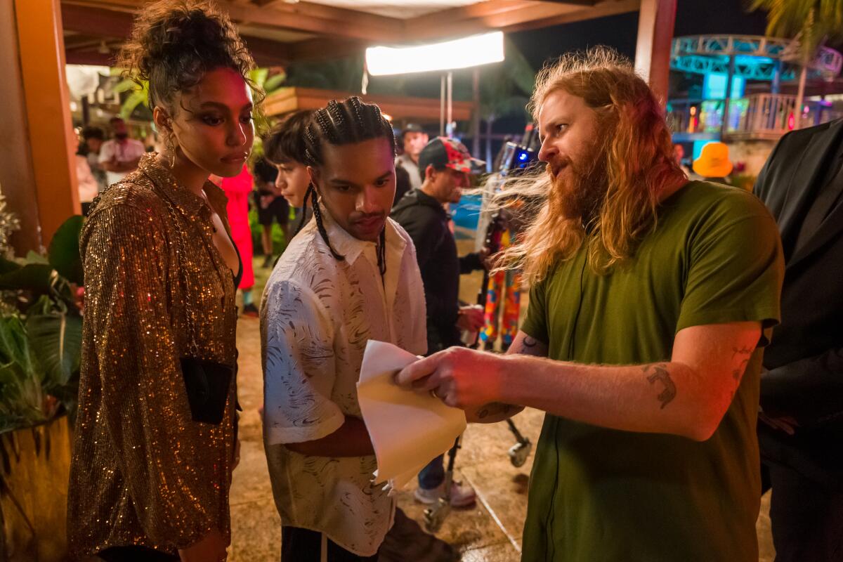 Three people talk on the set of "Neon."