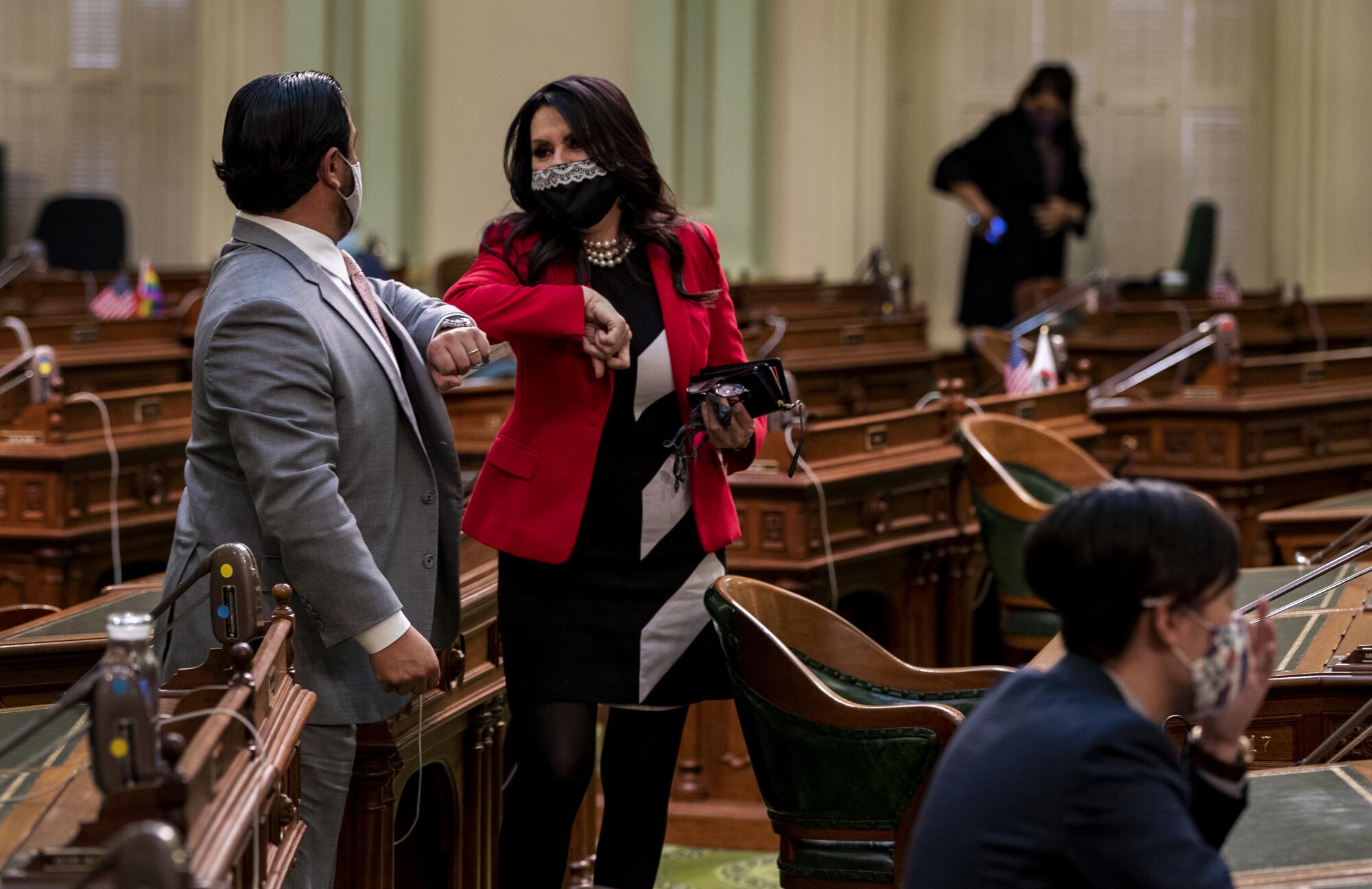 Assemblyman Carlos Villapudua bumps elbows with Assemblywoman Blanca Rubio in the California state Capitol.