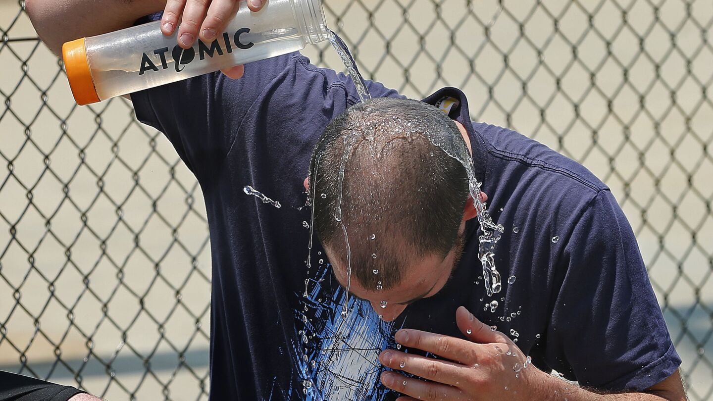 Jeremy Albucher of Los Feliz cools off with water after playing in a three-on-three pickup basketball game at North Hollywood Park in North Hollywood on Friday.