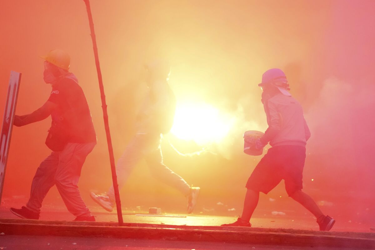 Manifestantes llamados "desactivadores" y activistas de "primera línea" se enfrentan con policías durante una protesta contra el gobierno, el sábado 28 de enero de 2023, en Lima. (AP Foto/Martín Mejía)