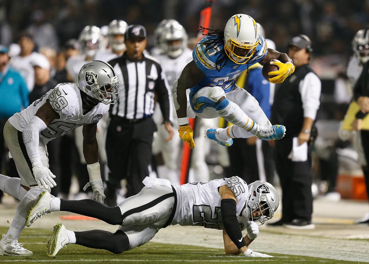 Chargers running back Melvin Gordon jumps over Oakland Raiders safety Erik Harris.