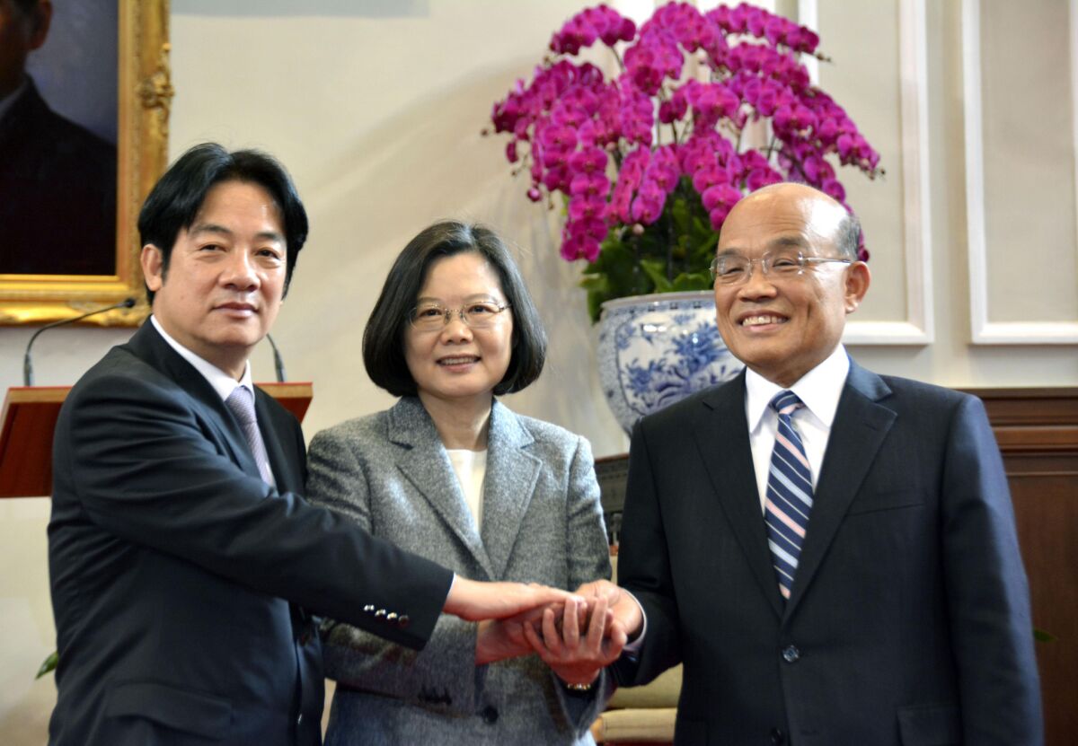 Former Premier William Lai, from left, President Tsai Ing-wen and new Premier Su Tseng-chang join hands during a news conference Friday in Taipei, Taiwan.