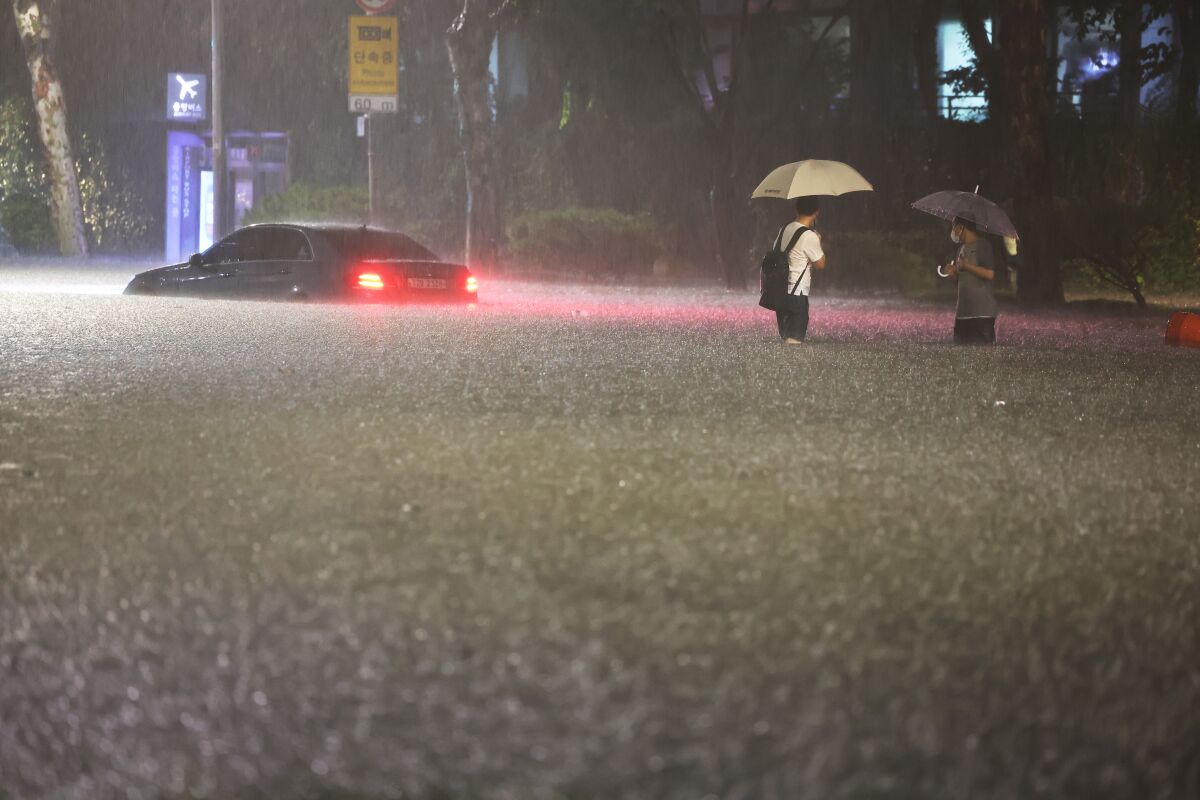 A vehicle is submerged in a flooded road in Seoul, Monday, Aug. 8, 2022. Heavy rains drenched South Korea's capital region, turning the streets of Seoul's affluent Gangnam district into a river, leaving submerged vehicles and overwhelming public transport systems. (Hwang Kwang-mo/Yonhap via AP)
