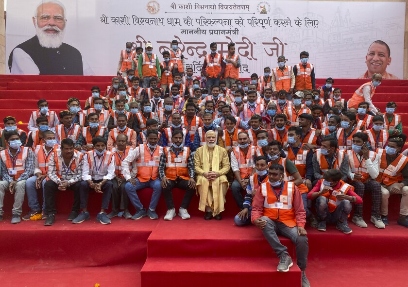 Indian Prime Minister Narendra Modi, center, poses with workers during the inauguration of Kashi Vishwanath Dham Corridor, a promenade that connects the sacred Ganges River with the centuries-old temple dedicated to Lord Shiva in Varanasi, India, Monday, Dec. 13, 2021. (AP Photo/Rajesh Kumar Singh)