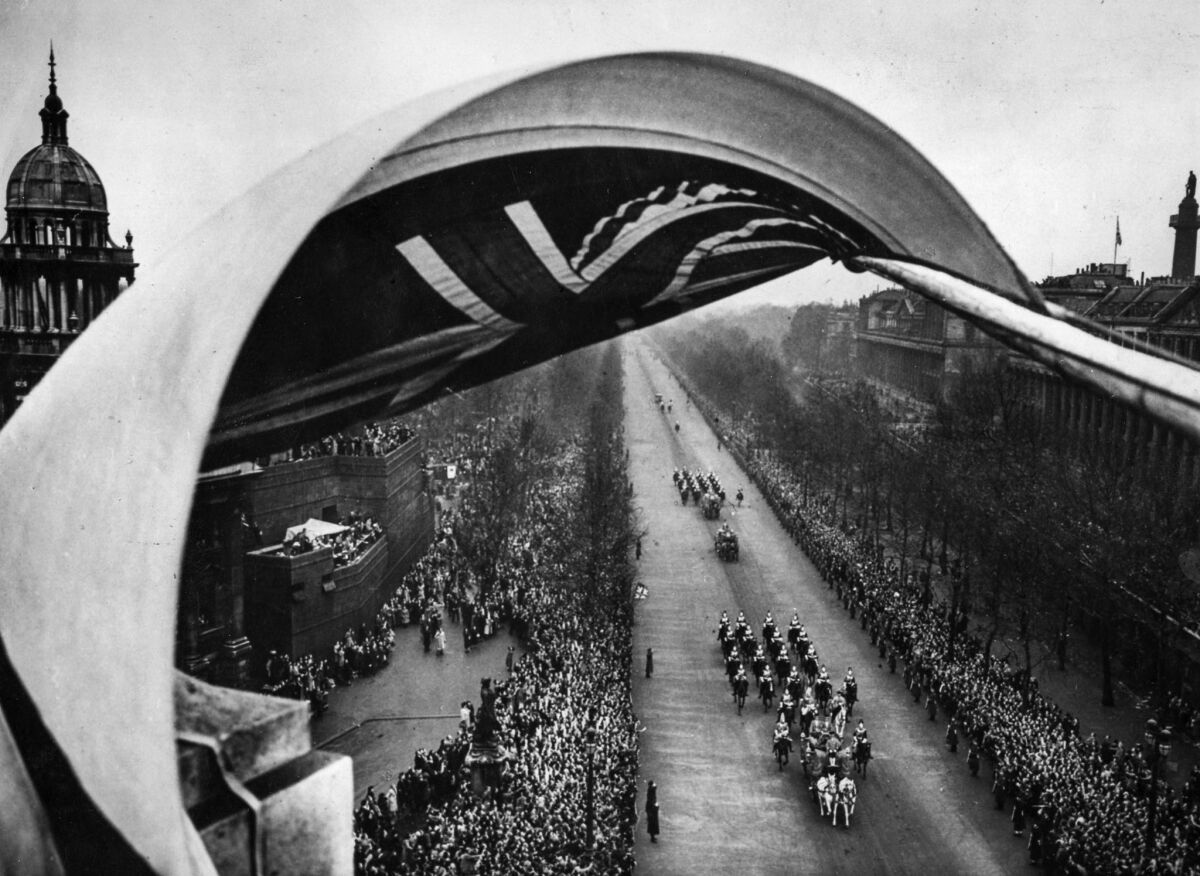 Nov. 20, 1947: A billowing flag, part of the decorations on Admiralty Arch, frames the royal bridal procession as it passes on its way to Westminster Abbey.
