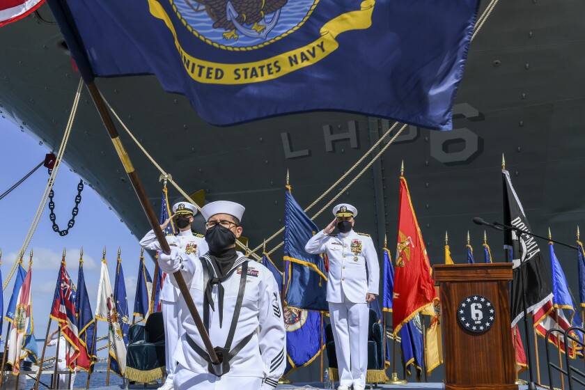 This photo provided by the U.S. Navy shows Rear Adm. Philip Sobeck, Commander, Expeditionary Strike Group Three, and Capt. G. S. Thoroman, commanding officer, amphibious assault ship USS Bonhomme Richard, salute the ensign for colors during a decommissioning ceremony at Naval Base San Diego April 14, 2021. The U.S. Navy has decommissioned the USS Bonhomme Richard docked off San Diego nine months after flames engulfed it in one of the worst U.S. warship fires outside of combat in recent memory. The ceremony Wednesday at Naval Base San Diego was not public with the Navy citing concerns over the spread of the coronavirus. (Mass Communication Specialist 2nd Class Alex Millar/U.S. Navy via AP)