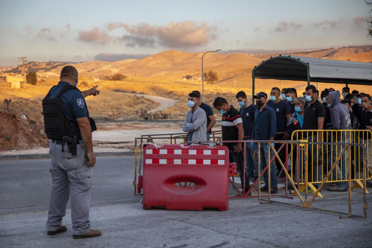Palestinian laborers line up at a checkpoint to enter the Israeli settlement Maale Adumim.