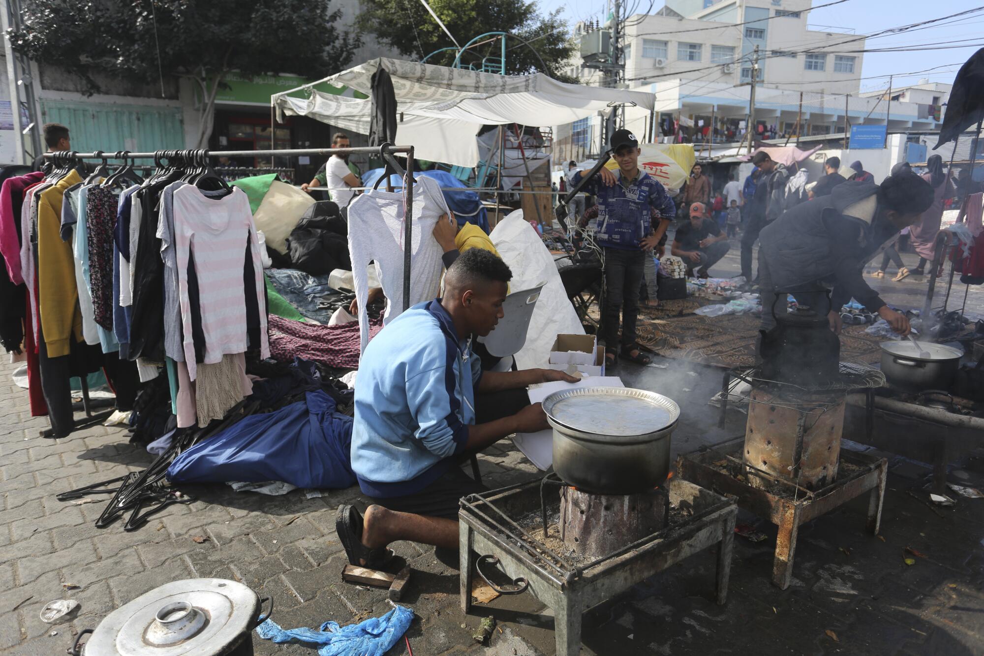 People cooking outside in a square in Rafah, in the Gaza Strip