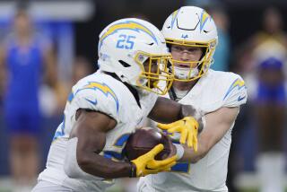 Los Angeles Chargers quarterback Easton Stick, right, hands off to running back Joshua Kelley.