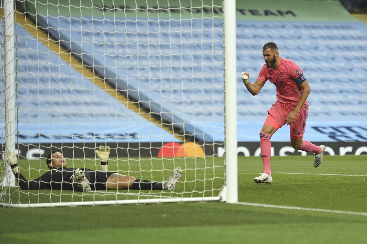 Real Madrid's Karim Benzema celebrates after scoring his side's first goal during the Champions League, round of 16, second leg soccer match between Manchester City and Real Madrid at the Etihad Stadium stadium in Manchester, England, Friday, Aug. 7, 2020. (Oli Scarff/Pool Photo via AP)