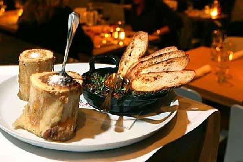 The luscious interior of the roasted beef marrow is of ready to be scooped out with a small spoon. On the side is an oxtail jam, the shredded meat cooked and reduced until its butter tender.