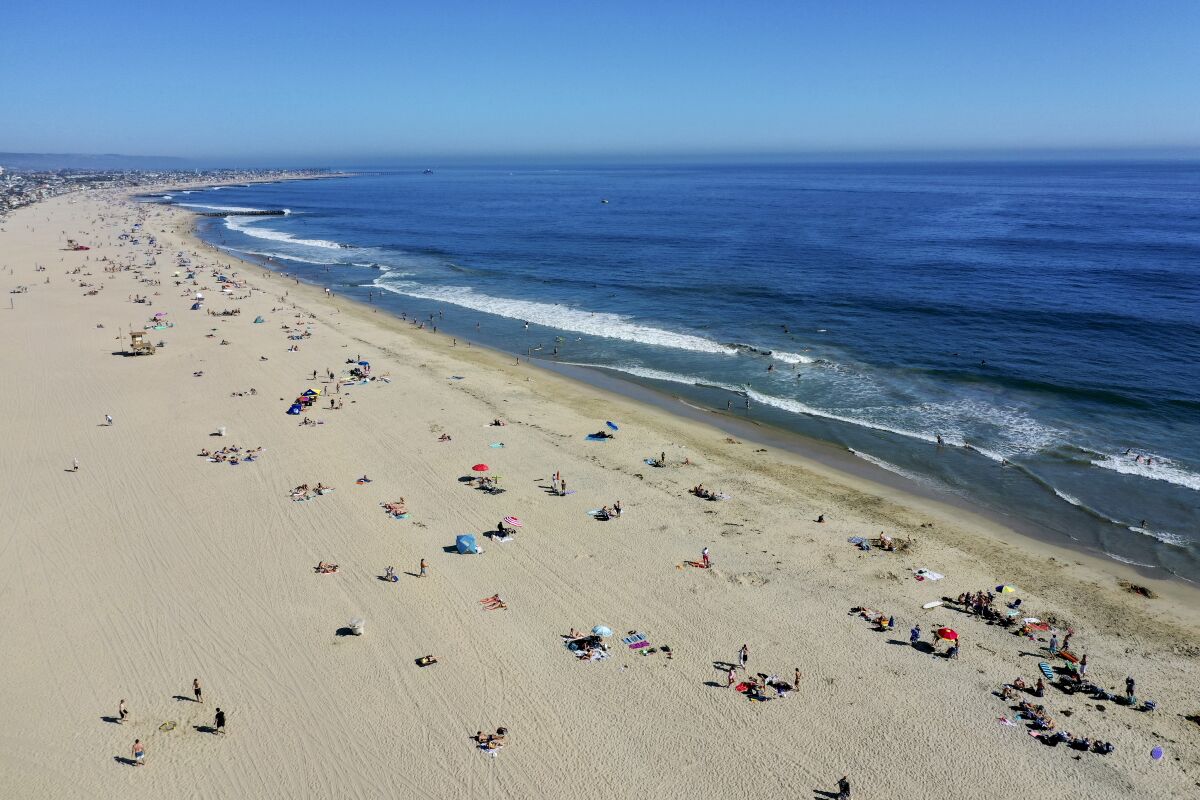 An aerial view shows beachgoers scattered on the sand in Newport Beach on April 25.