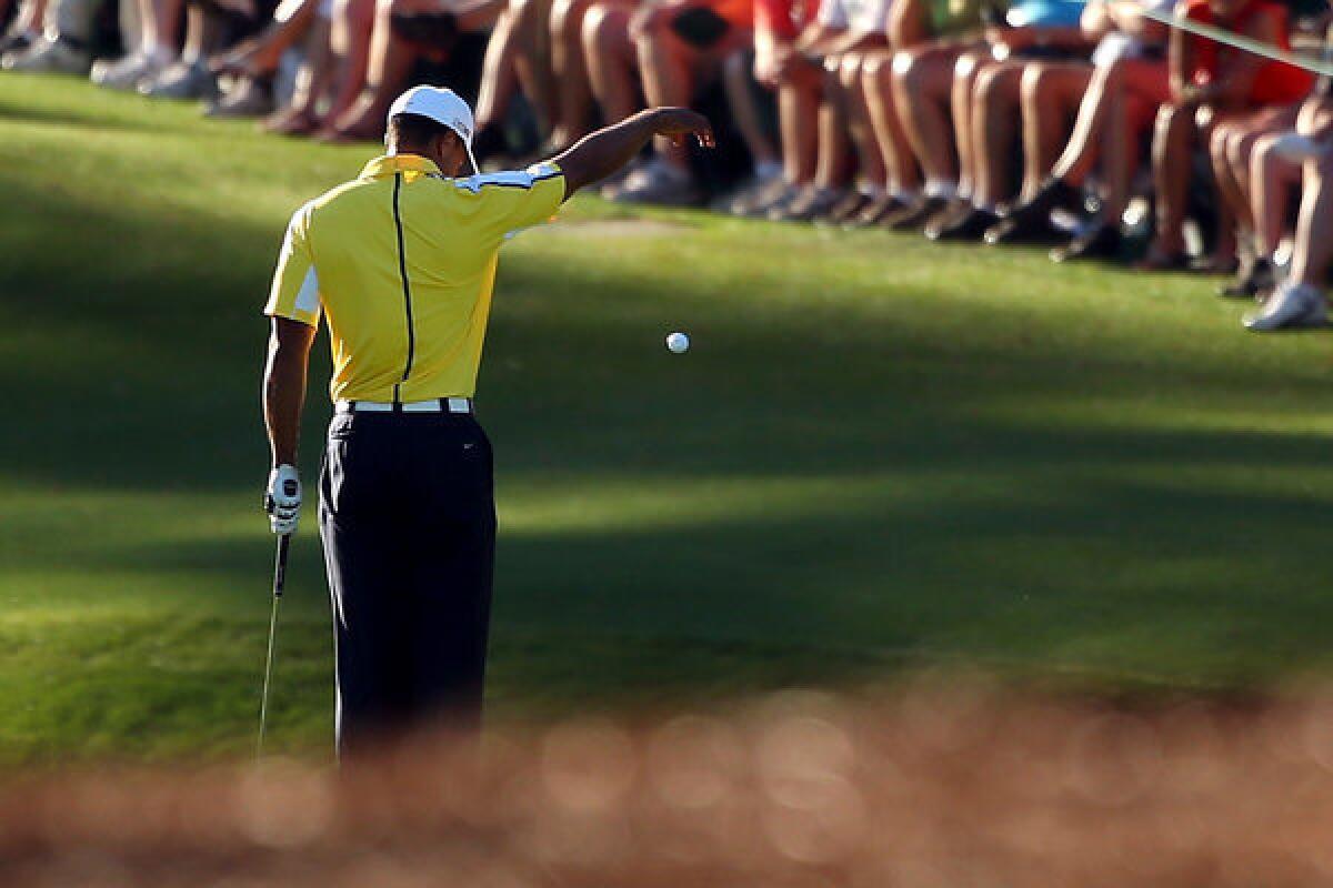 Tiger Woods drops his ball after he hits it into the water on the 15th hole during the second round of the 2013 Masters Tournament at Augusta National Golf Club in Augusta, Ga.