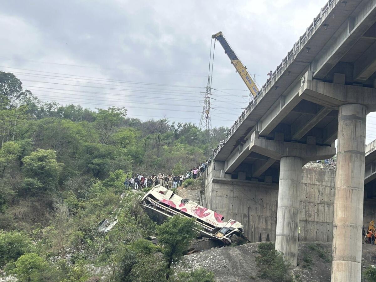 Rescuers preparing crane to lift crashed bus