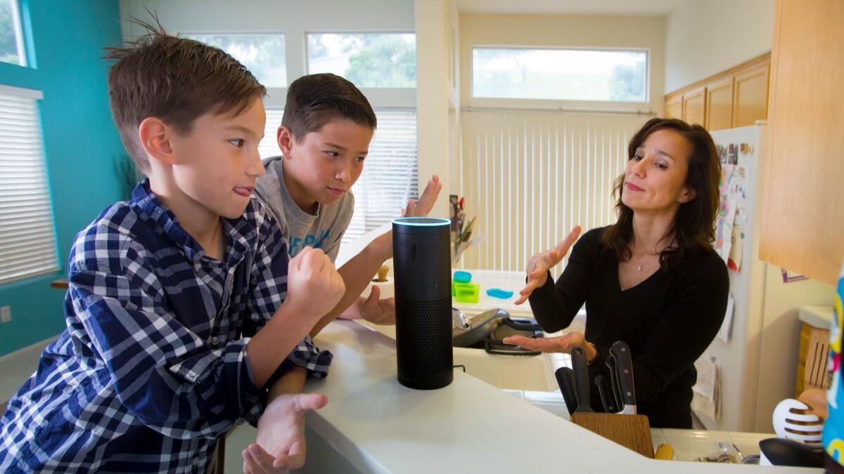 Family members play a game of rock-paper-scissors with “Alexa,” their Amazon Echo wireless speaker and voice command personal assistant, at their home in San Diego’s Scripps Ranch community.