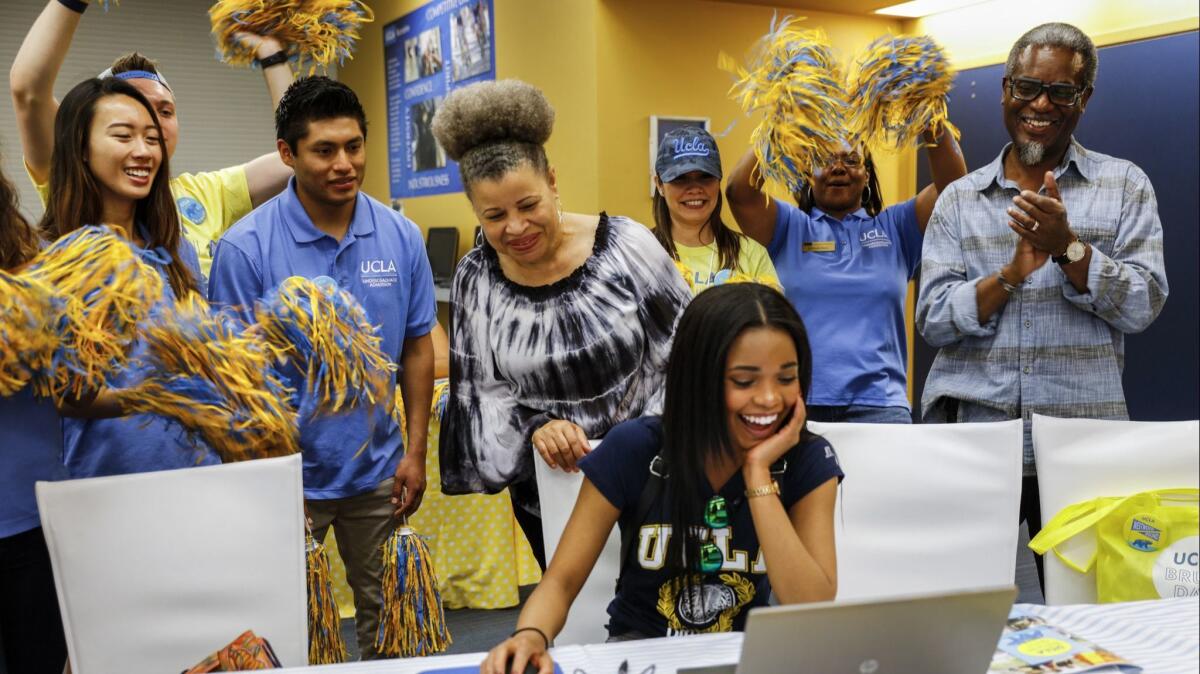 Amora Haynes, center, from Vallejo, signs her intent to enroll at UCLA. The University of California and Cal State systems aim to boost enrollment in the upcoming academic year.