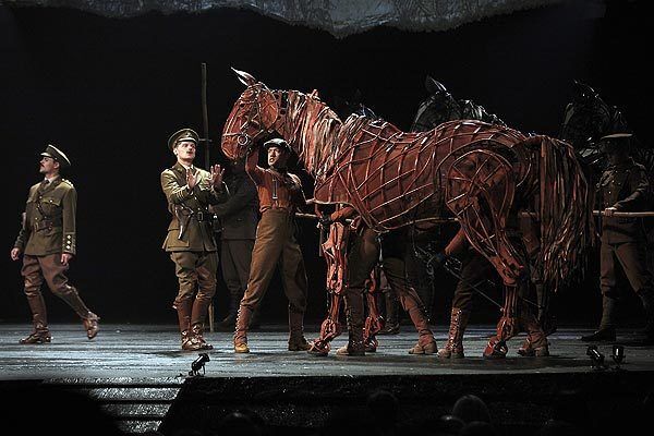 Jason Laughlin (Lieutenant James Nicholls) tries to calm Joey in the Tony-winning play "War Horse" at the Ahmanson Theatre. Puppeteer Christopher Mai operates the head of Joey.