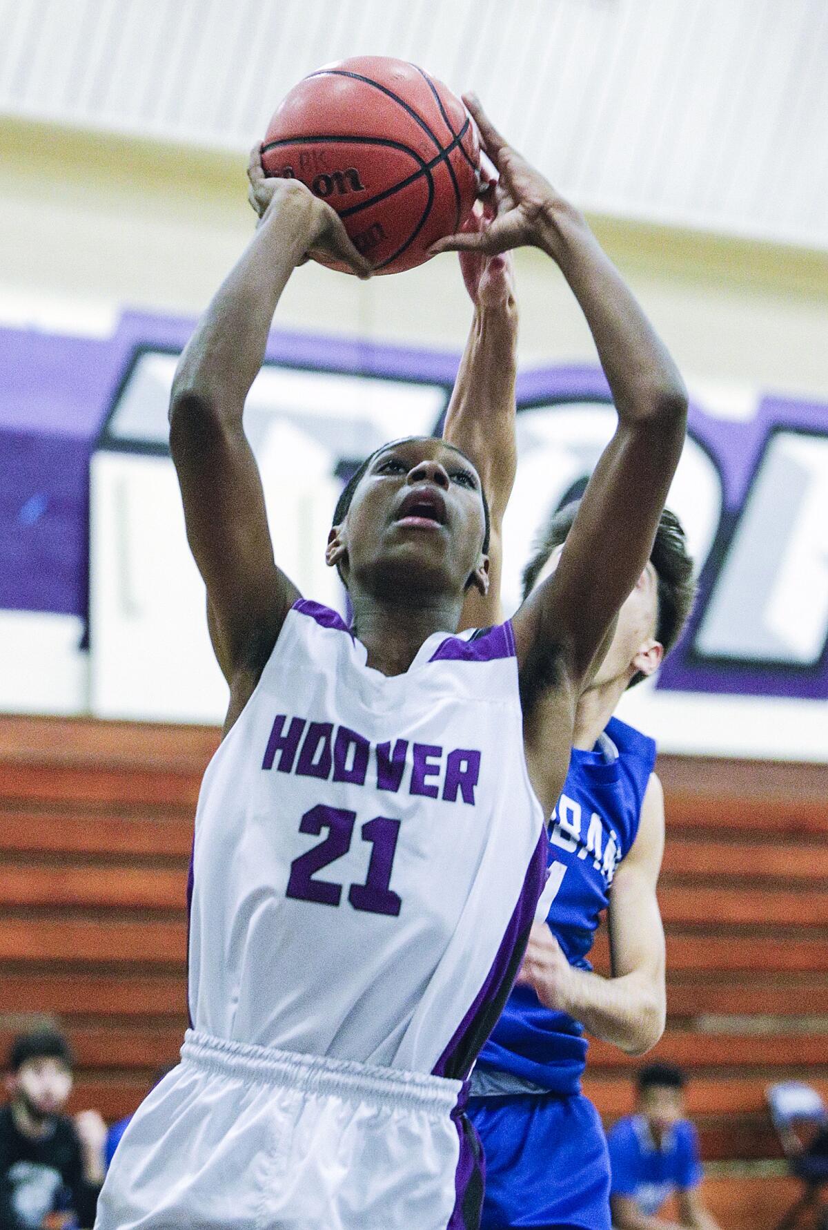 As Hoover's Jeremiah Townsend drives on an attempt to score, Burbank's Vartan Avetisyan gets a touch on the shot to deflect it from scoring in a Pacific League boys' basketball game at Hoover High School on Friday, January 3, 2020.