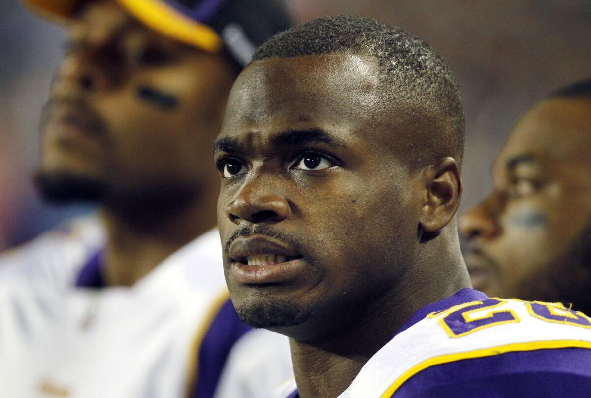Minnesota Vikings running back Adrian Peterson watches from the sidelines in 2011.