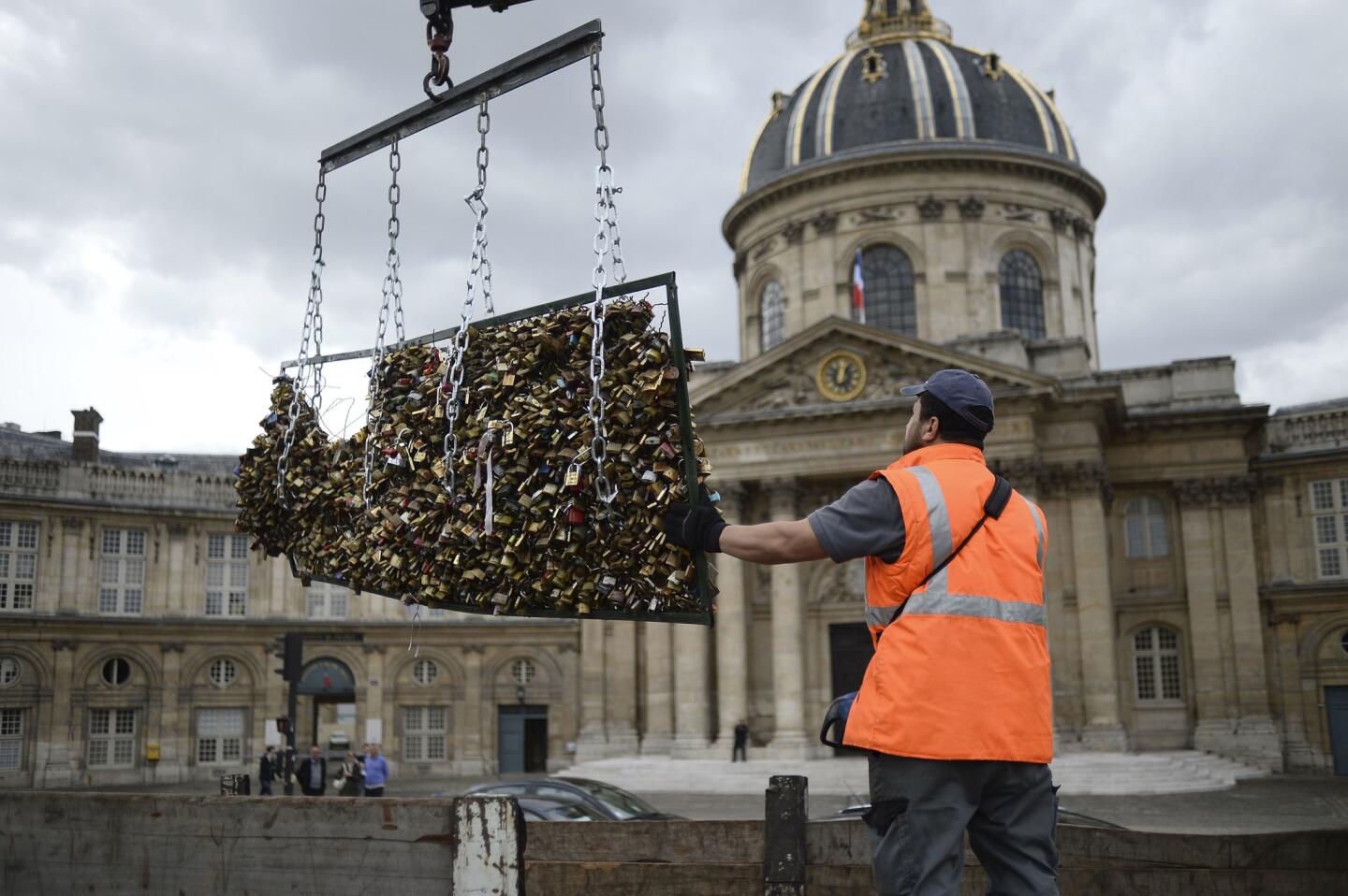 A worker removes padlocks attached to the railings of the Pont des Arts on June 1, 2015, in Paris.