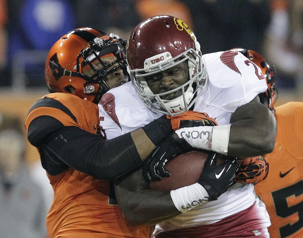 USC running back Silas Redd picks up some tough yards against defensive back Tyrequek Zimmerman and Oregon State on Friday night at Reser Stadium.