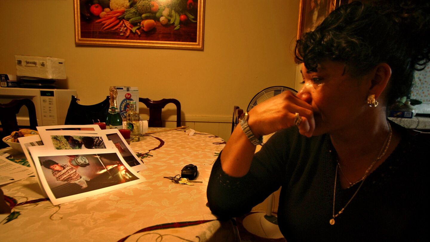 Maria Georgina Nunez, 47, cries while looking at a photo of son Denis in her San Diego apartment in December 2003. It shows him as a 12-year-old, asleep on a Mexican freight train during his struggle to reach San Diego.