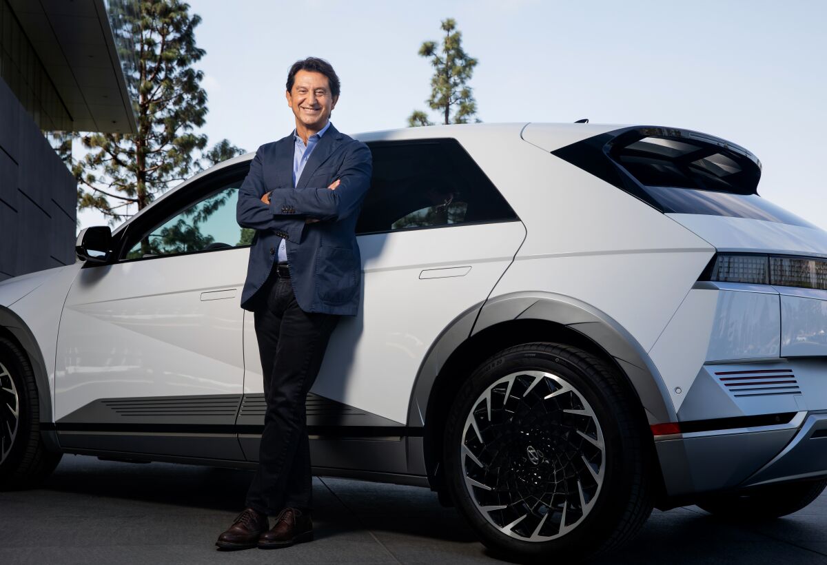 Hyundai-Genesis North American CEO Jose Munoz standing in front of white Hundai Ioniq 5.