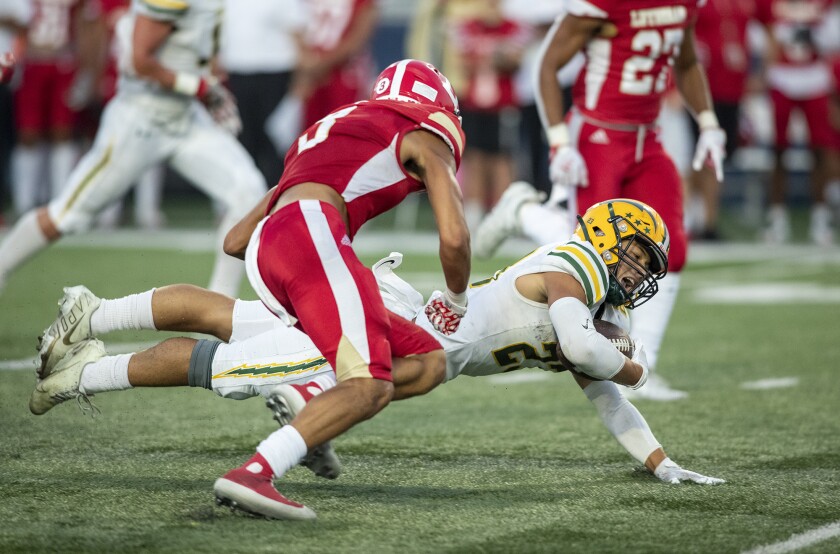 Edison's Nico Brown dives past Orange Lutheran's Jaylen Lynch during Friday's game.
