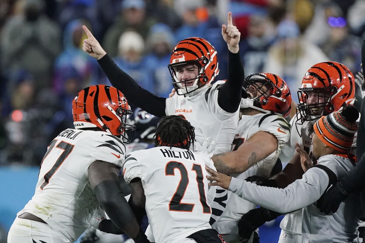 Evan McPherson, top center, celebrates with Bengals teammates after his field goal beat the Tennessee Titans in the playoffs.