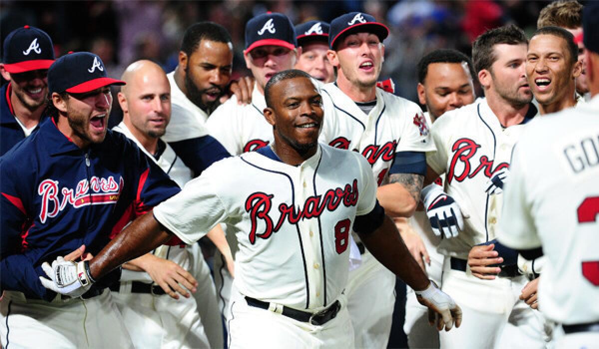 Justin Upton is congratulated by his Braves teammates after a game-winning home run against the Chicago Cubs on April 6.