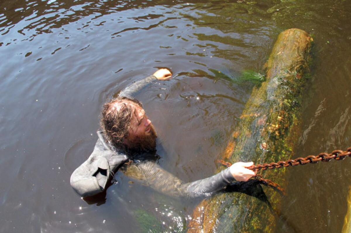 Hewitt Emerson guides a longleaf pine log to a barge after diving to the bottom of the Edisto River in South Carolina.