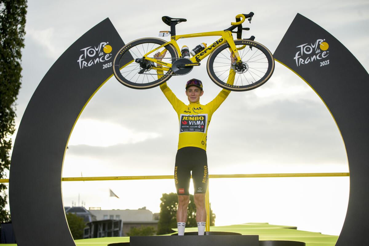 Tour de France winner Jonas Vingegaard celebrates on the podium.