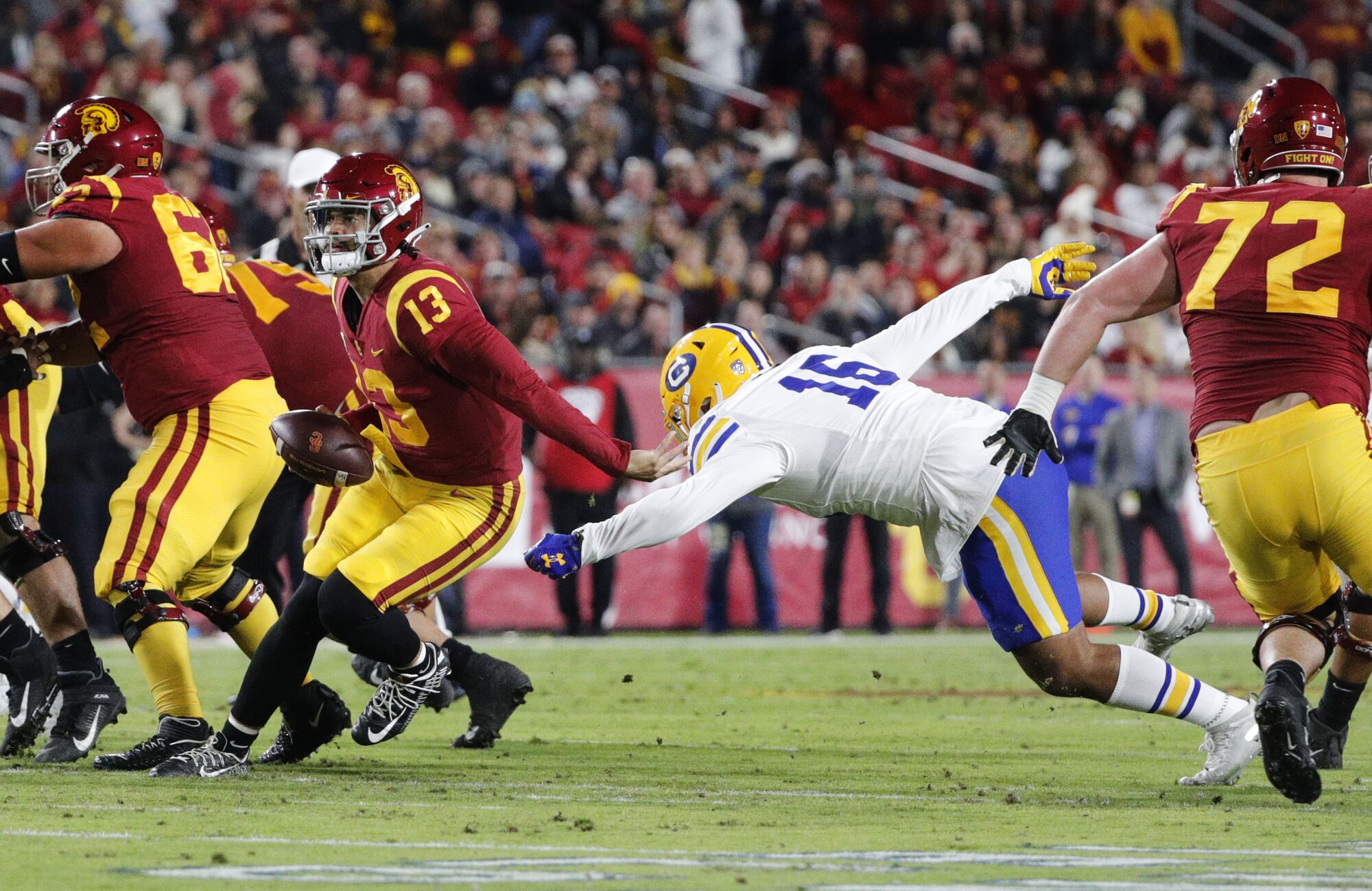 USC quarterback Caleb Williams (13) evades a sack attempt by California  linebacker Henry Ikahihifo (16).