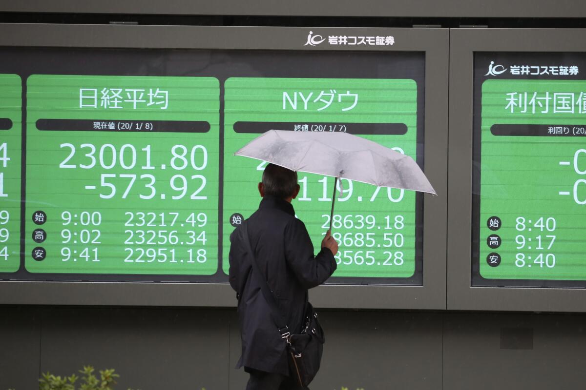 A man pauses at a security firm's electronic stock board Jan. 8 in Tokyo.