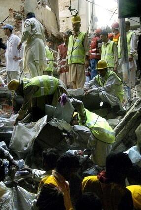 Pakistani rescuers remove debris