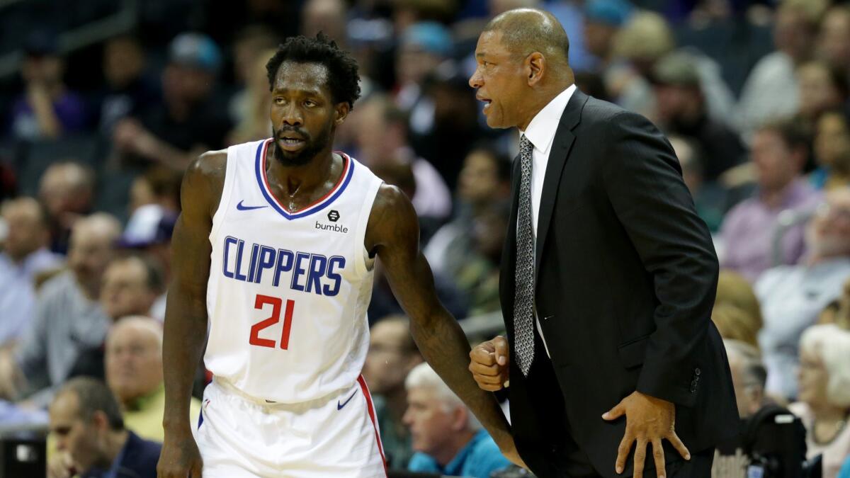 Clippers guard Patrick Beverley speaks with coach Doc Rivers during a game against the Charlotte Hornets on Feb. 5.