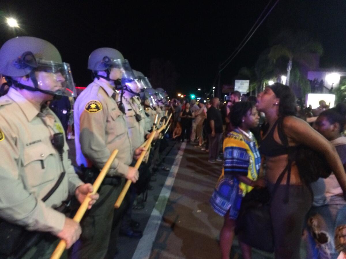 Demonstrators yell at police in El Cajon at a rally against the shooting of Alfred Olango.