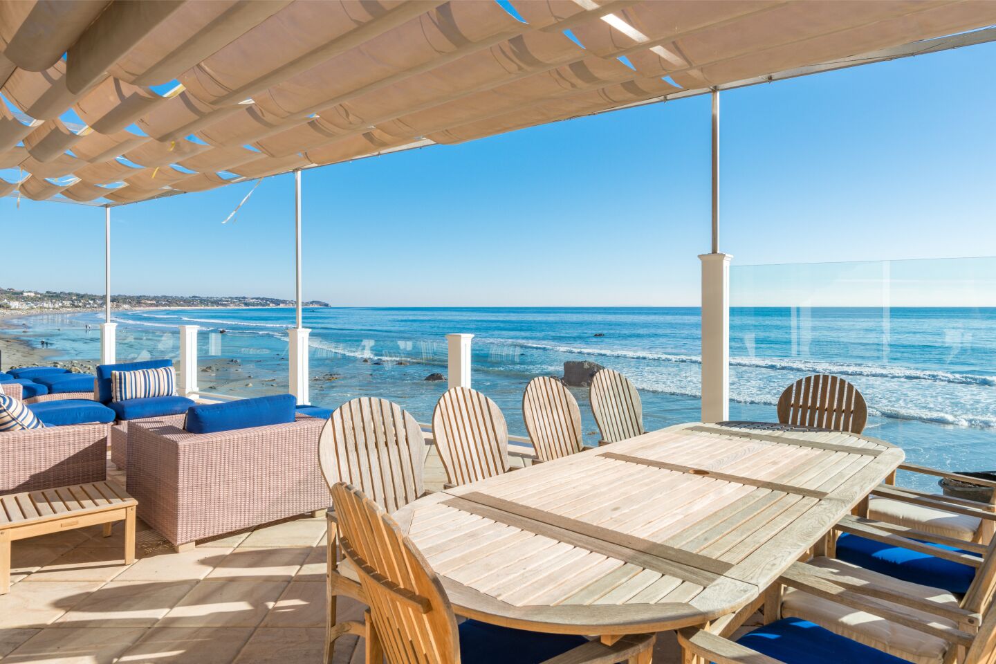 The covered dining deck has tables and chairs and an ocean view.