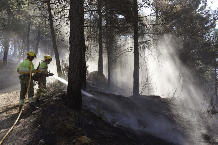Dos bomberos intentan apagar un incendio forestal el 29 de marzo de 2023, en Fuente la Reina, Castellón de la Plana, España. (AP Foto/Alberto Saiz)