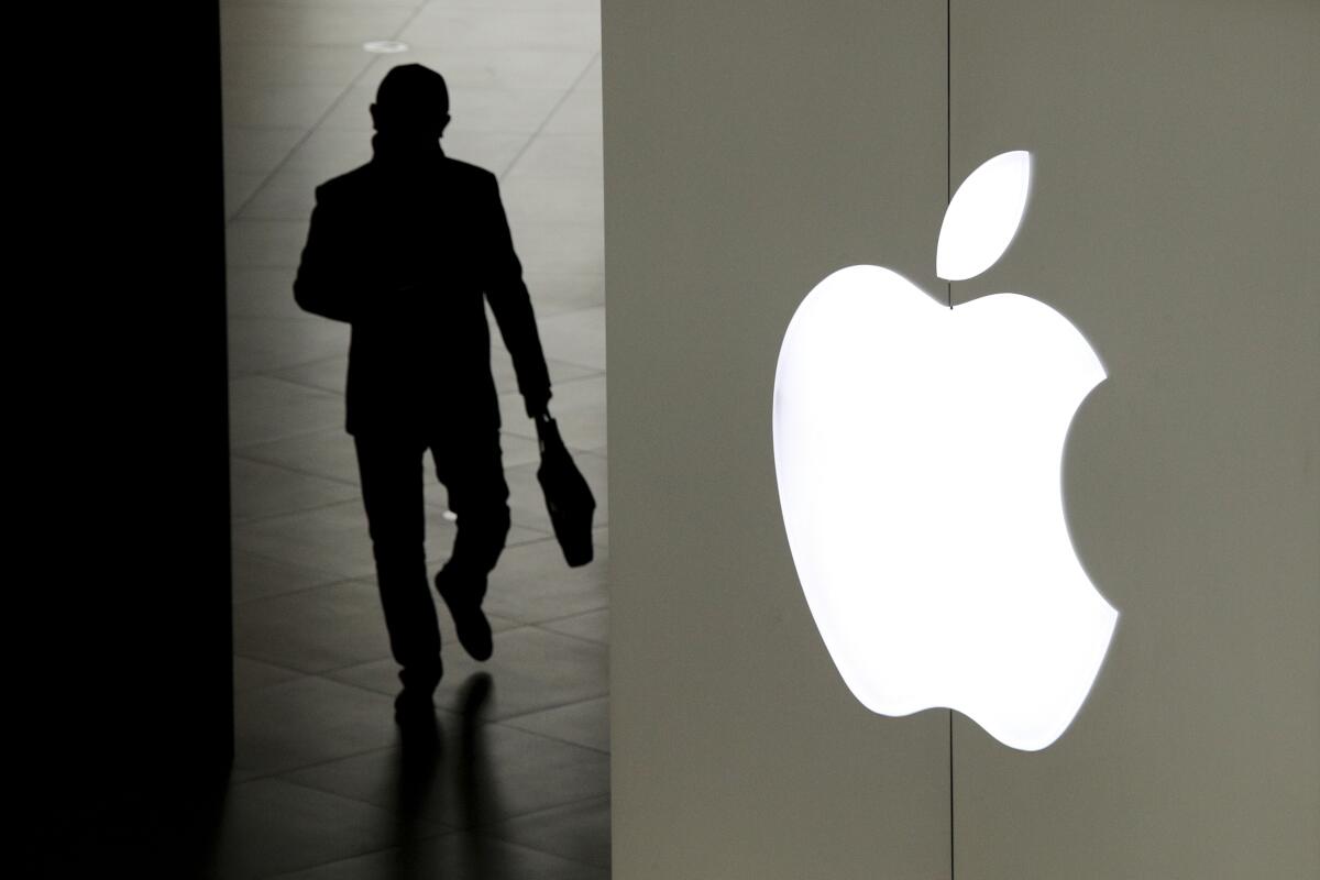 A silhouette of a man leaving an Apple store.