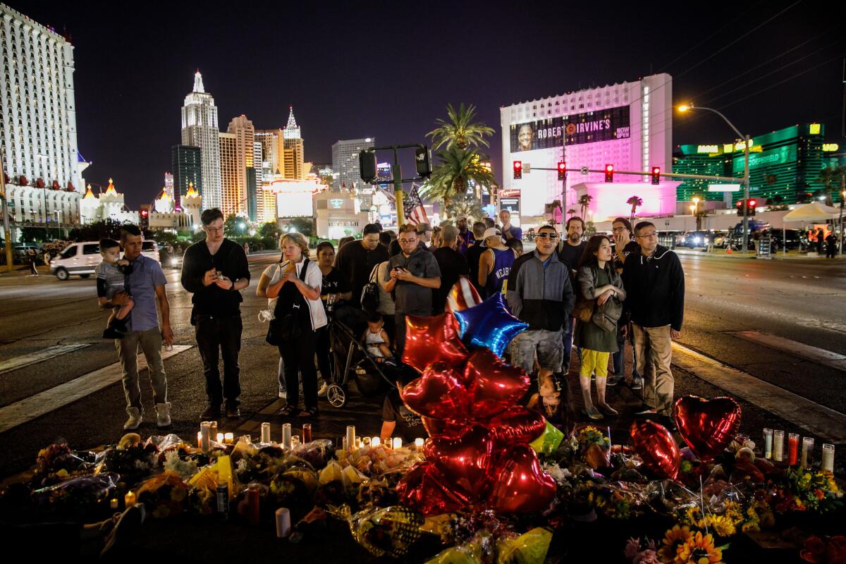 People visit a makeshift memorial for shooting victims on Reno Avenue and Las Vegas Boulevard.