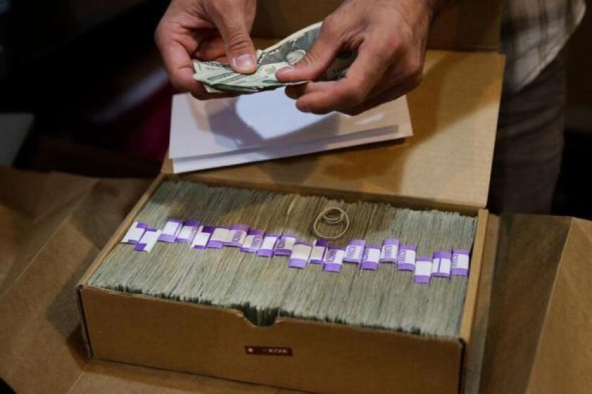 Un propietario de un dispensario de marihuana medicinal en Los Ángeles prepara su pago mensual de impuestos, el 27 de junio pasado (Jae C. Hong / Associated Press).