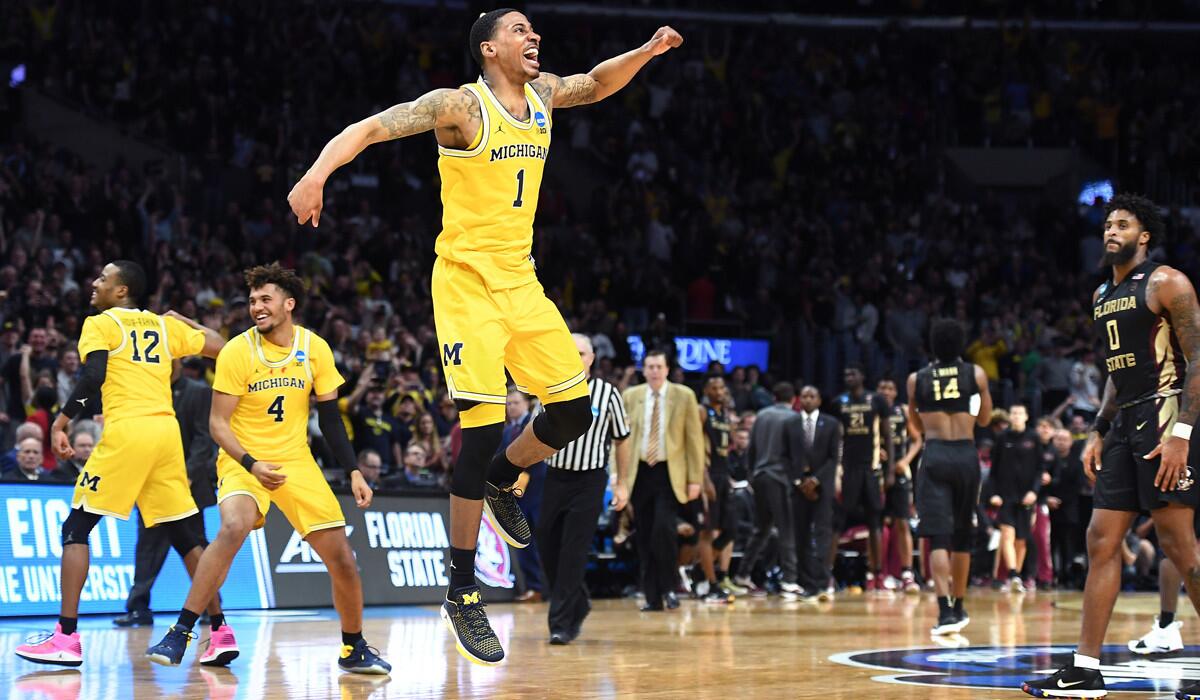 Michigan's Charles Matthews, center, celebrates at the end of the game to defeat Florida State in the regional final of the NCAA tournament.