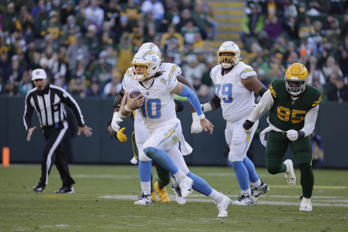 Chargers quarterback Justin Herbert (10) runs out of the pocket against the Green Bay Packers.