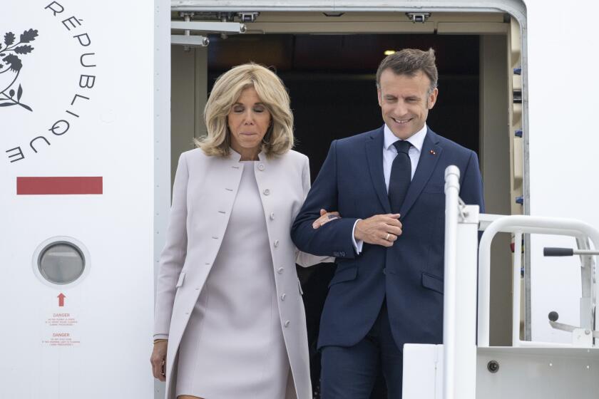 French President Emmanuel Macron and his wife Brigitte Macron arrive at the military section of BER Airport, in France, ahead of their three-day state visit to Germany, Sunday, May 26, 2024. (Christophe Gateau/dpa via AP)