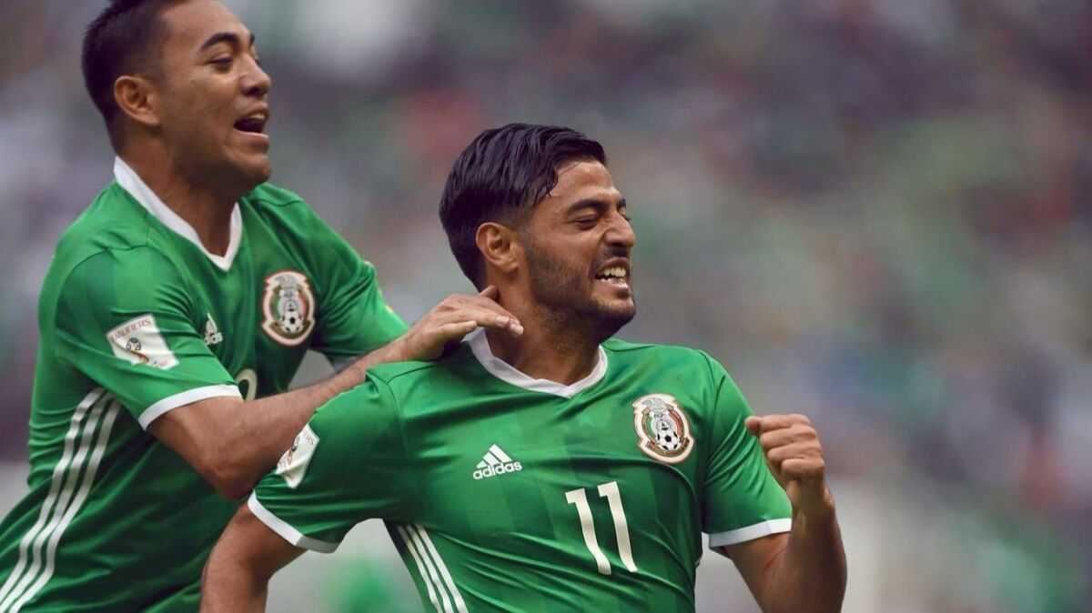 Mexico's forward Carlos Vela, right, celebrates with teammate Marco Fabian after scoring against the U.S. during their 2018 World Cup CONCACAF qualifier match, in Mexico City on June 11, 2017.