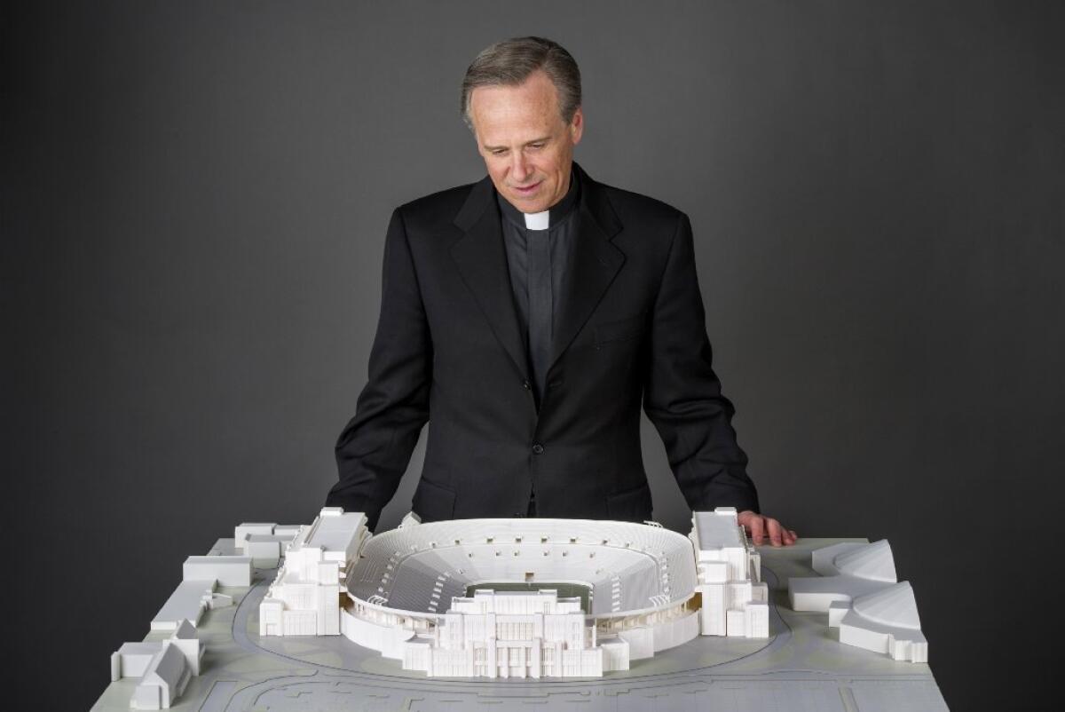 University of Notre Dame President John I. Jenkins looks at a model of the school's new football stadium.