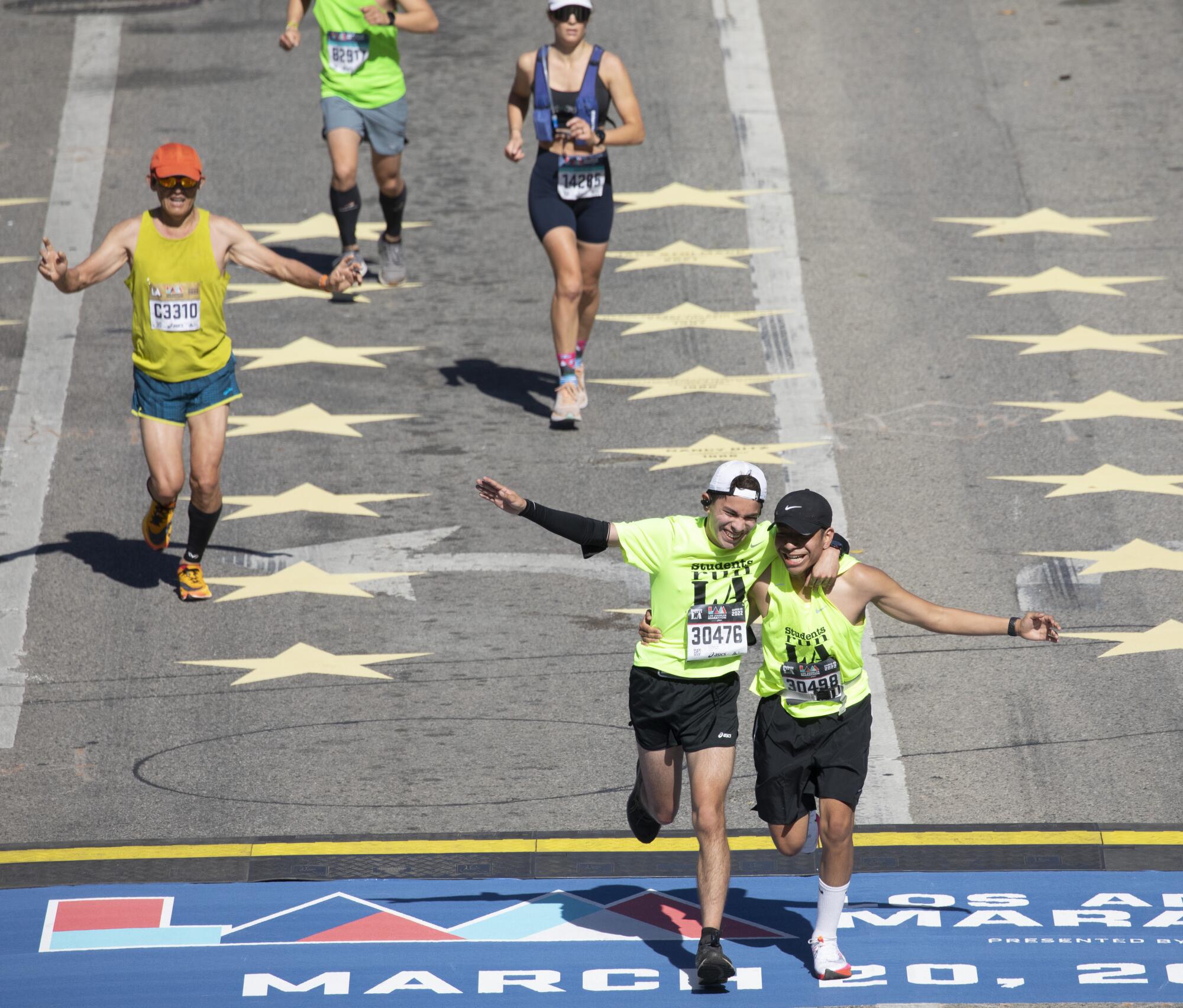 Runners cross the finish line on Avenue of the Stars