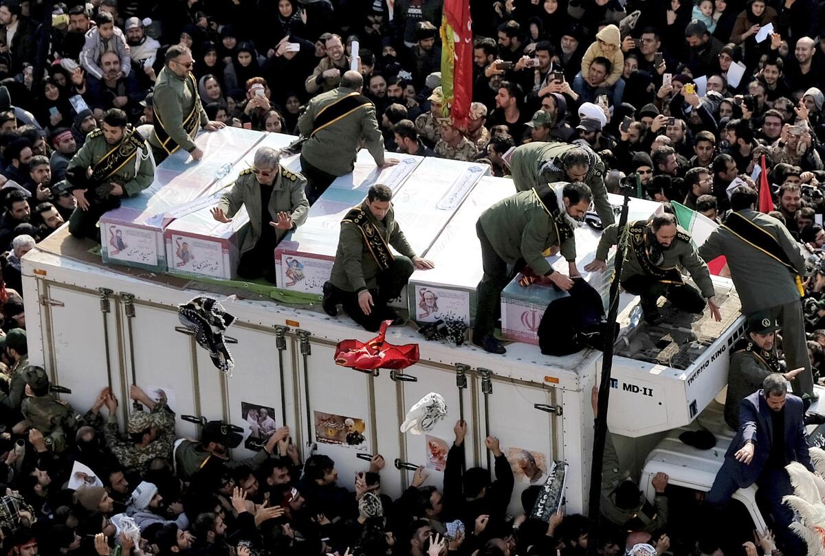 The coffins of Gen. Qassem Suleimani and others who were killed in Iraq by a U.S. drone strike are carried on a truck surrounded by mourners during a funeral procession in Tehran.